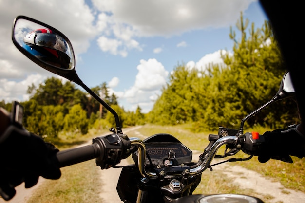 Biker riding motorbike on dirt road