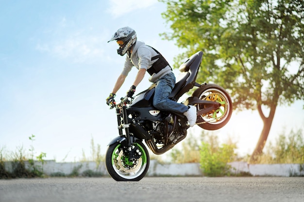 Biker standing on one cycle