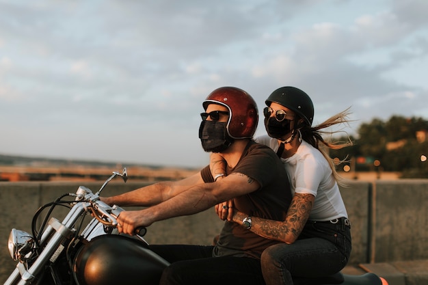 Free photo bikers wearing masks in the new normal lifestyle