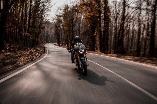 Biking a motorcycle in the forest.