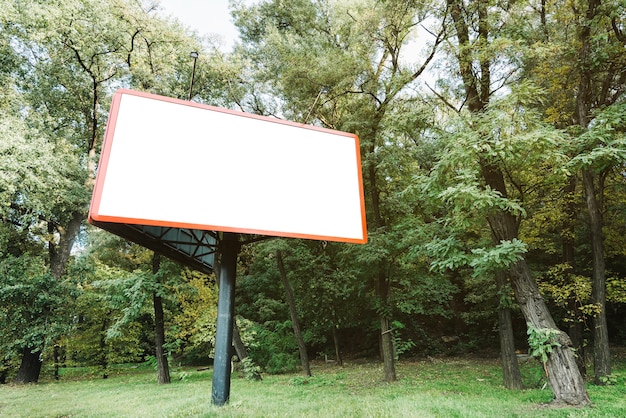 Бесплатное фото Рекламный щит возле леса