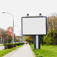 Free photo billboard with two lamp near the sidewalk in the city