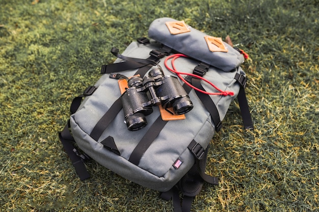 Бесплатное фото Бинокли и рюкзак на траве