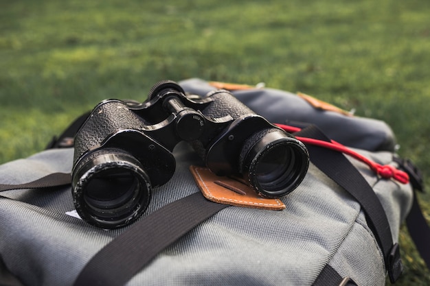 Бесплатное фото Бинокль, лежащий на рюкзаке