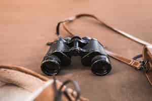 Free photo binoculars between shoes and bag