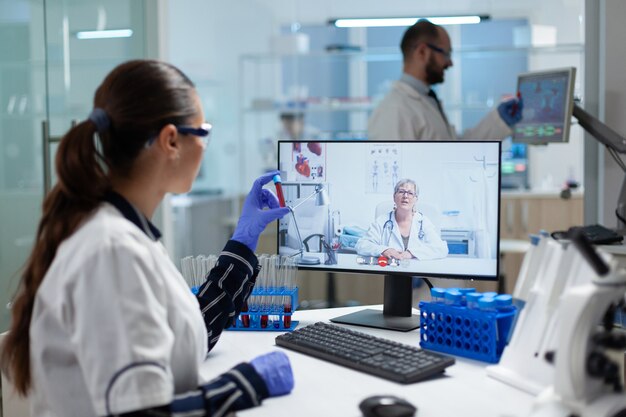 Biologist researcher woman holding blood test tube in hands discussing medical vaccine