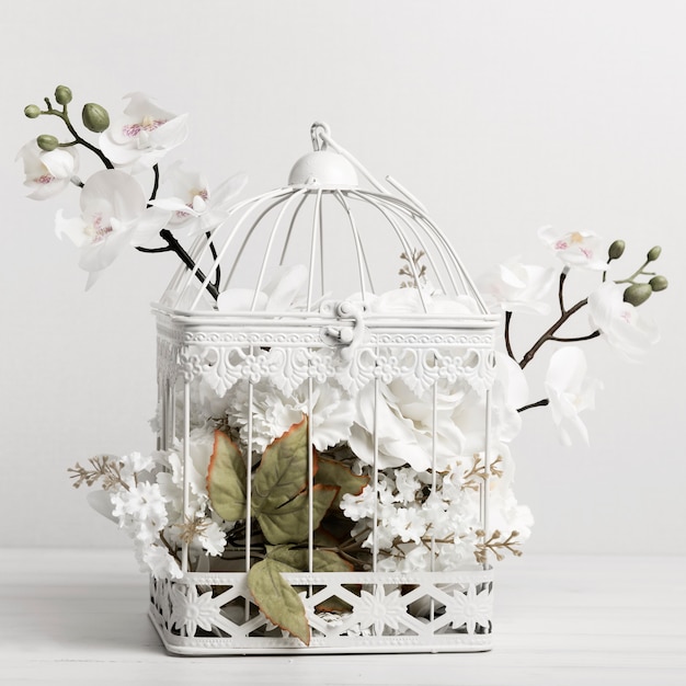 A bird cage full of beautiful flowers
