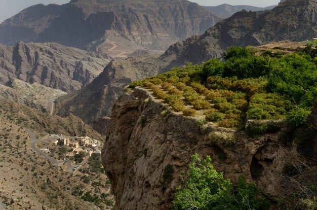 Bird-eye shot of huge and picturesque mountains and cliffs partly covered in green trees