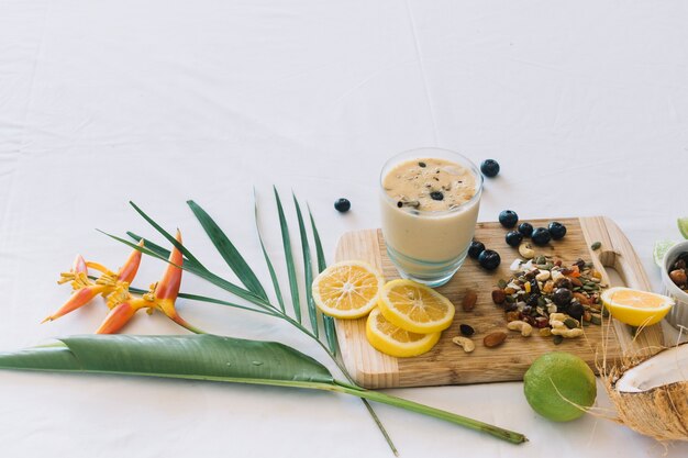 Bird of paradise flower; smoothie with dryfruits and citrus fruits on white background