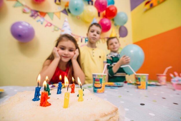 Birthday cake near blurred children
