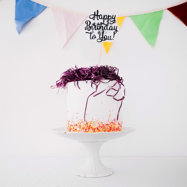 Birthday cake with writing and tinsel