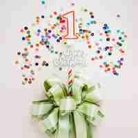 Free photo birthday candle with bow surrounded by sequins