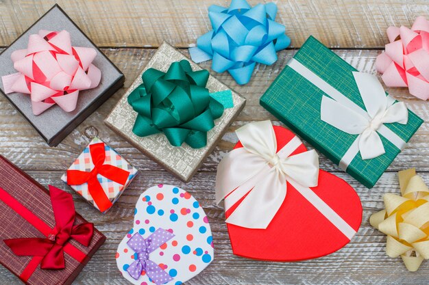 Birthday concept with assorted gift boxes, bows on wooden background flat lay.