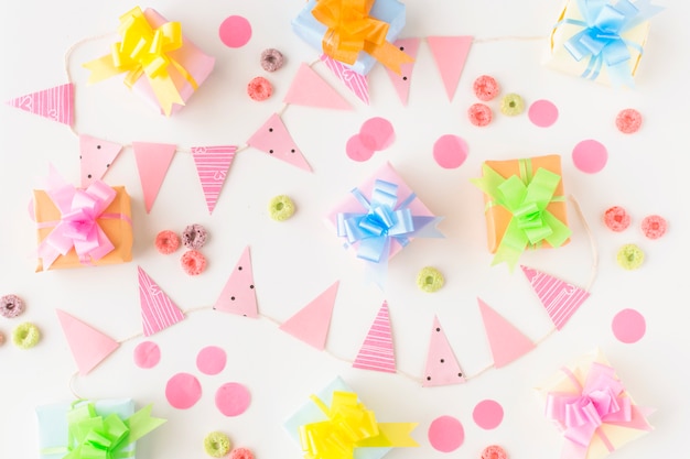 Birthday gifts; froot hoops candies and party accessories on white background