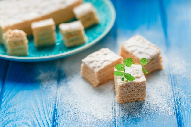 Foto gratuita pastila della caramella della mela della torta del dolce del biscotto, foglie di menta sul fondo di legno blu del tagliere.