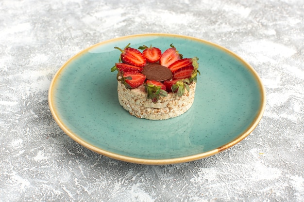 biscuit with strawberries and round chocolate inside blue plate