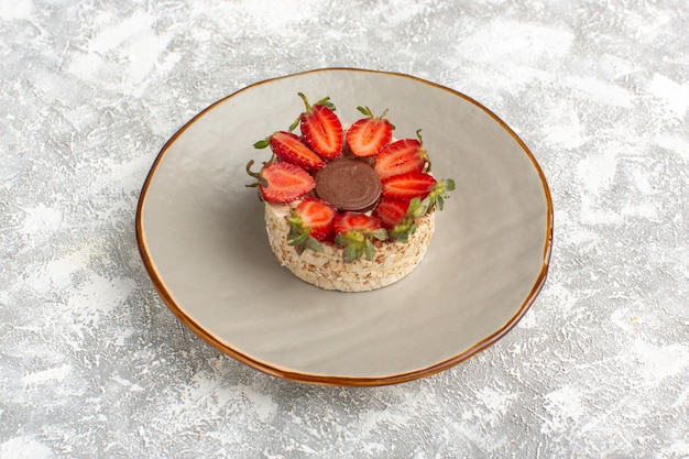 Free photo biscuit with strawberries and round chocolate inside plate
