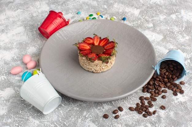 biscuit with strawberries and round chocolate inside purple plate along with coffee seeds and candies