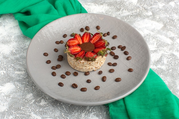 biscuit with strawberries and round chocolate inside purple plate along with coffee seeds