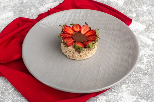 Biscuit with strawberries and round chocolate inside purple plate