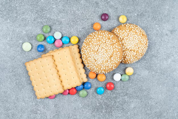 Biscuits and colorful candies on marble surface