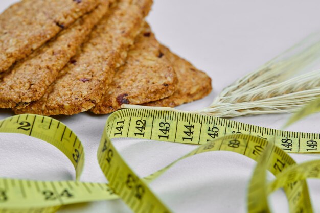 Biscuits and tape measure on white.