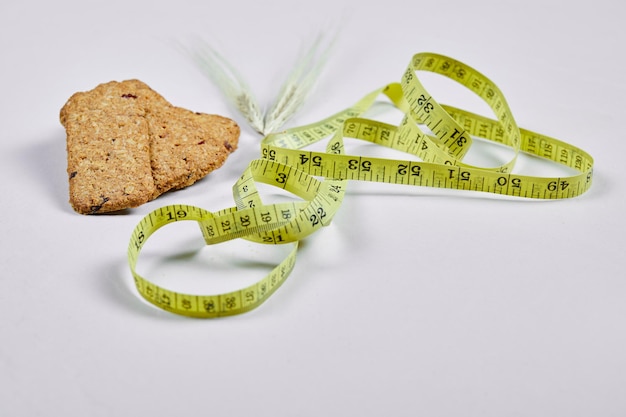 Biscuits and tape measure on white.