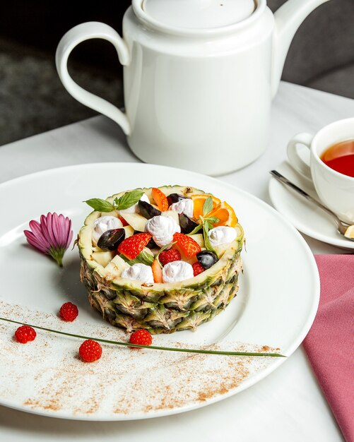 Bisquits and sliced vegetables served in pineapple