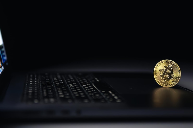 Free Photo bitcoin coin near laptop on black background finance and crypto money concept
