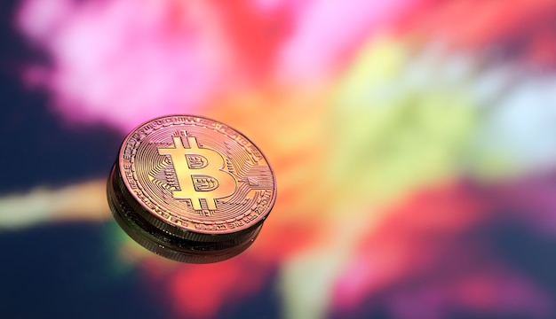 Bitcoin is a new concept of virtual money on a colorful background, a coin with the image of the letter B, close-up.
