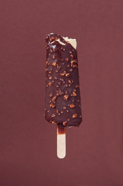 茶色の背景にかまれたダークチョコレートアーモンドアイスクリーム