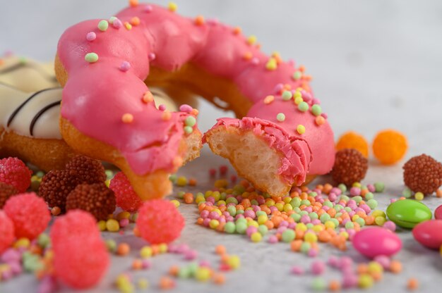 Bitten strawberry donut  decorated icing and sprinkling on the floor