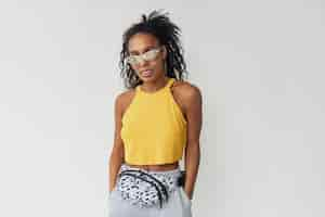 Free photo black african american woman in stylish hipster outfit yellow top on white