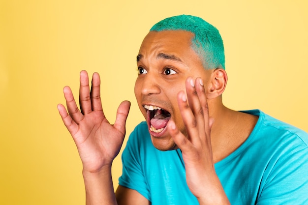 Черный африканский мужчина в повседневной одежде на желтой стене громко кричит с широко открытым ртом