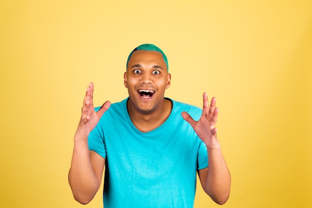 Free photo black african man in casual on yellow wall  with shocked amazed surprised face open mouth