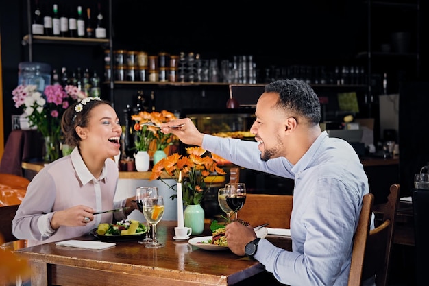 Чернокожие американцы, мужчина и женщина, едят веганскую еду в ресторане.