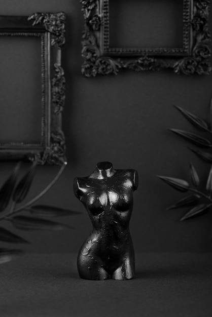 Free photo black background with statue and frames