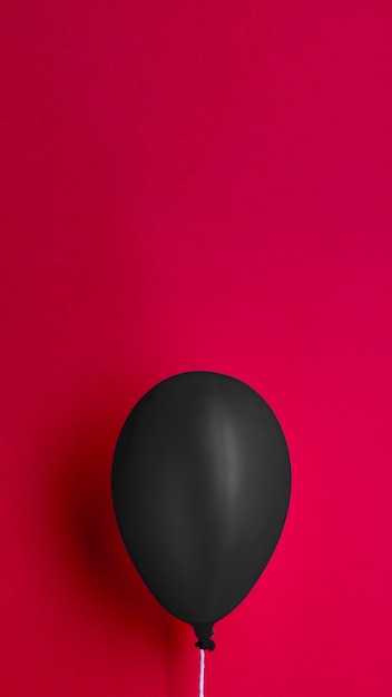 Black balloon on red background