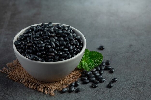 black beans in white small bowl place on dark floor