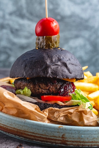 Hamburger di manzo nero servito con patatine fritte