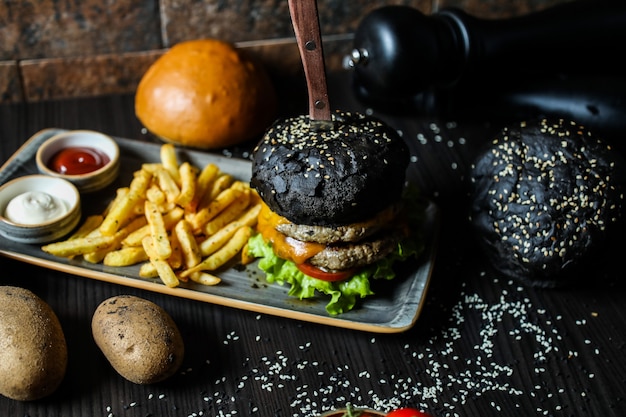 食材とフライドポテトの黒ビーフハンバーガー