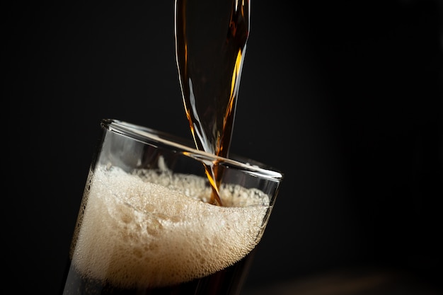 Foto gratuita birra nera su legno