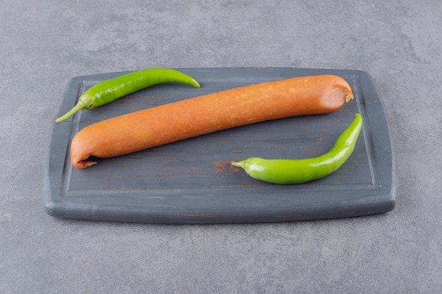 Free photo a black board of boiled sausages with chili peppers