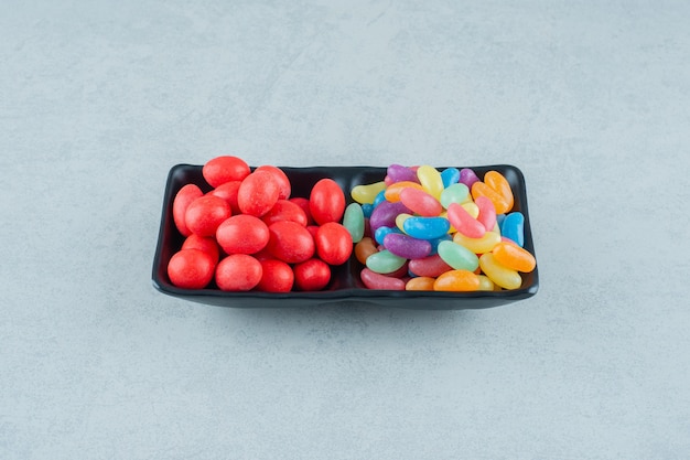 A black board full of colorful beans candies on a white surface