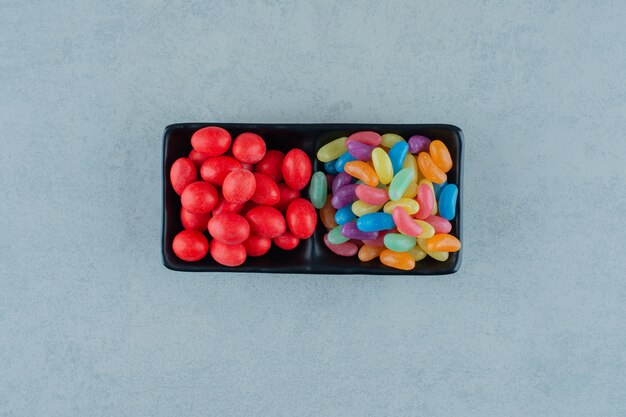 A black board full of colorful beans candies on a white surface