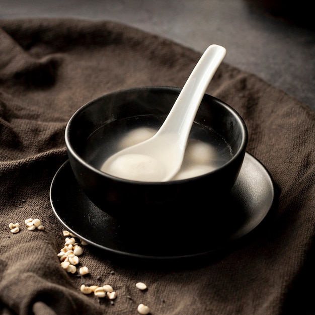 Black bowl of soup in a black cloth