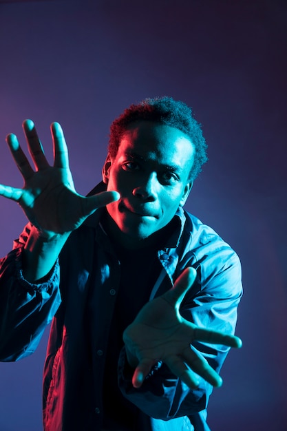 Free photo black boy posing with blue light