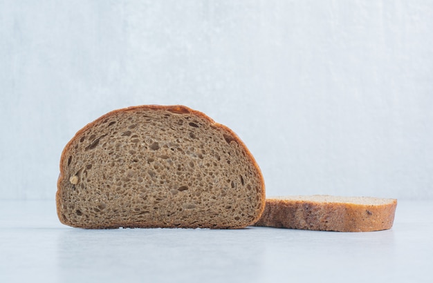 Бесплатное фото Ломтики черного хлеба на синем фоне. фото высокого качества