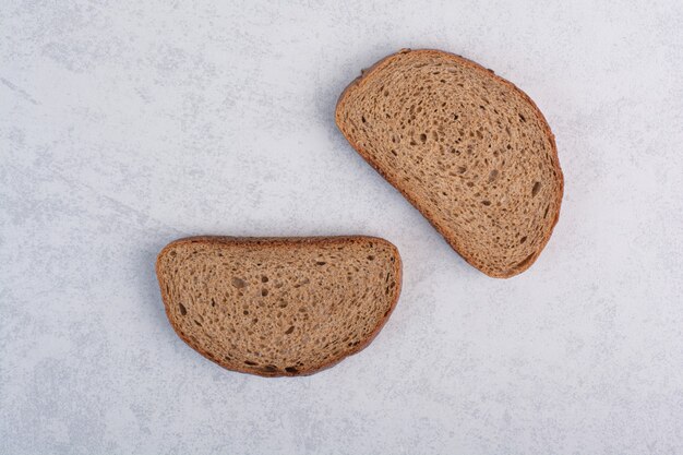 Black bread slices on stone surface