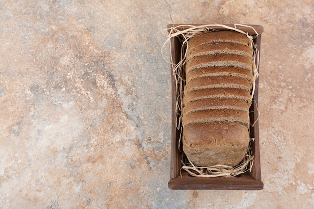 Fette di pane nero nella ciotola di legno